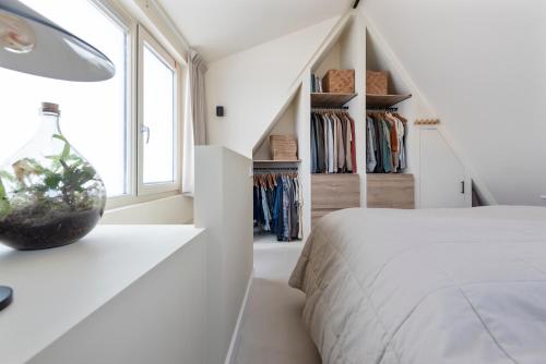 een slaapkamer met een wit bed en een raam bij The Modern Burrow in Zandvoort