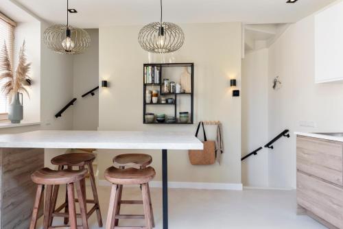 een keuken met een aanrecht en 2 krukken bij The Modern Burrow in Zandvoort