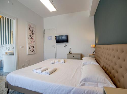 een slaapkamer met een groot bed en 2 handdoeken bij Meravigliosa camera con finiture di lusso appena ristrutturata in Marina di Carrara