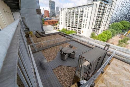 einen Balkon mit einem Tisch und Stühlen auf einem Gebäude in der Unterkunft 3 Bed Duplex Penthouse w/ Terrace in Birmingham