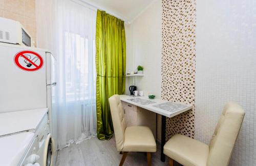 um pequeno quarto com uma mesa e cadeiras e uma cortina verde em Flat 24 on Basseynaya 17 studio em Kiev