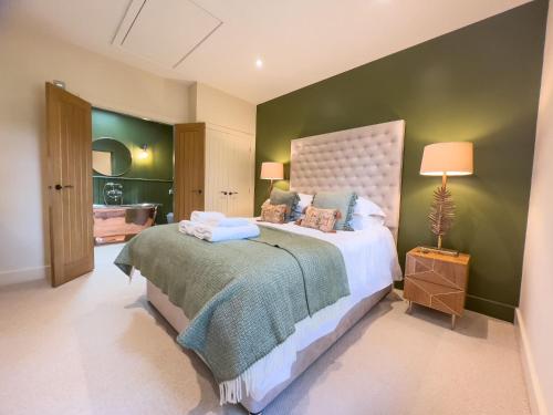 a bedroom with a large bed with a green wall at Waters Edge, Talkin Tarn, nr Brampton in Brampton