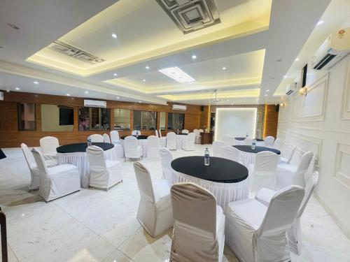 a banquet hall with white chairs and tables and a board at HOTEL GOLDEN TULIPZ in Mumbai