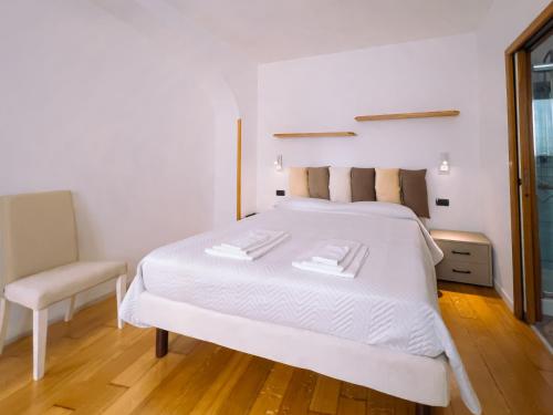 a bedroom with a white bed and a chair at Residenza Ester in Amalfi