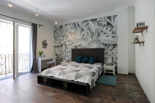 ブダペストにあるWest End Apartmentのベッドルーム1室(ベッド1台付)が備わります。壁に壁画が飾られています。