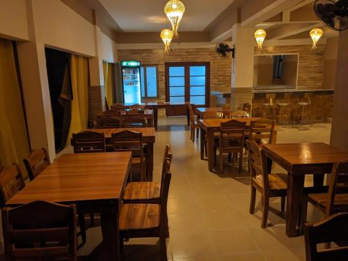 uma sala de jantar com mesas e cadeiras de madeira em Hôtel YABISSO em Lomé