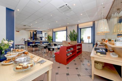 a cafeteria with a counter with food on it at Hotel Aurora in Desenzano del Garda