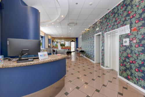 an office lobby with blue walls and a floral accent wall at Hotel Aurora in Desenzano del Garda