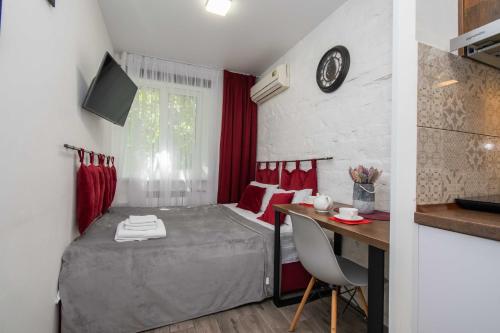 a small room with a bed and a desk and a kitchen at Апартаменти MYFREEDOM поруч із метро Тараса Шевченка in Kyiv