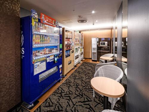 a room with two tables and a vending machine at APA Hotel Sapporo Odori Ekimae Minami in Sapporo