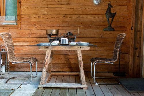 einen Holztisch mit zwei Stühlen in einem Zimmer in der Unterkunft Chalets in der Forststraße in Miltach