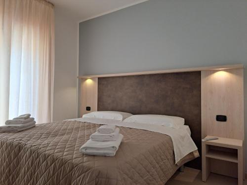 a bedroom with a large bed with towels on it at Maresol Residence in Bagnara Calabra