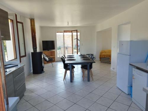 cocina con mesa y sillas en una habitación en Maison individuelle en Saint-Saulge