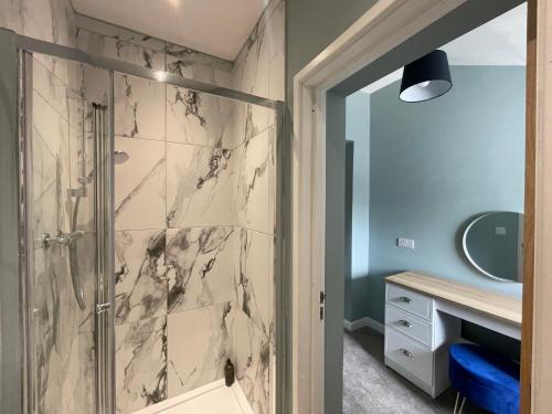 ein Bad mit einer Dusche und einem Waschbecken in der Unterkunft Silk Apartments Spondon in Derby
