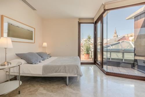 a bedroom with a bed and a large window at Green-Apartments Alto de Santa Cruz in Seville