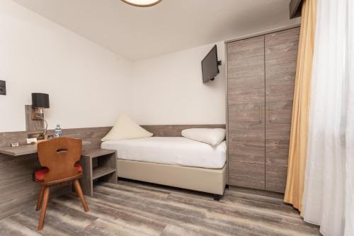 a bedroom with a bed and a desk and a chair at Alpenliebe in Sölden