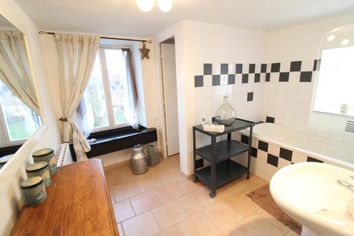 uma casa de banho com uma banheira, um lavatório e um WC. em Gîte La Belle Vosgienne em Aydoilles