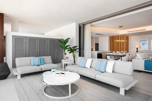 ein Wohnzimmer mit einem Sofa und einem Tisch in der Unterkunft Real de La Quinta Quercus Serenity Luxury Seaview Apartment Marbella in Benahavís