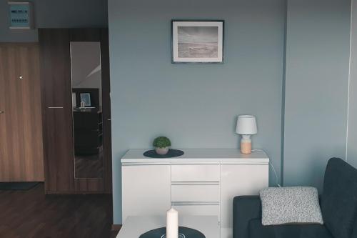 ブワディスワボボにあるMieszkanie Słoneczne Reja 2Bのリビングルーム(椅子、白いドレッサー付)