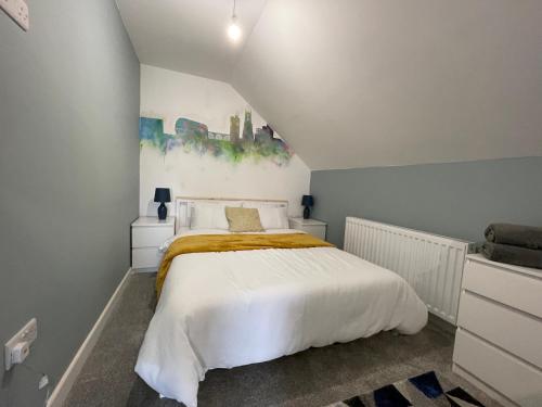 a bedroom with a white bed and a painting on the wall at Silk Apartments Spondon in Derby