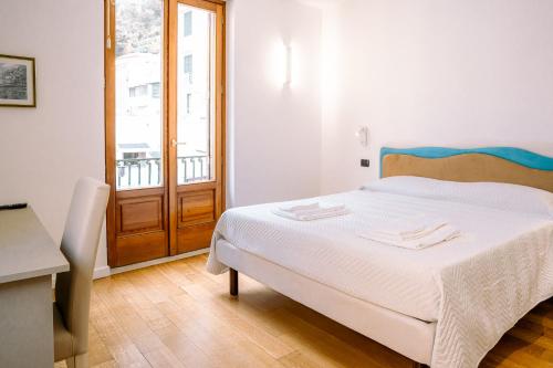 a bedroom with a bed with white sheets and a window at Residenza Ester in Amalfi