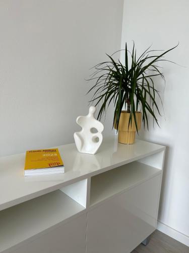 a white shelf with a plant and a book at Aurus 2 in Korčula