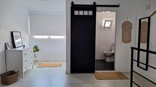 ein Bad mit einer schwarzen Tür und einem WC in der Unterkunft Esperanza 5 in Lebrija