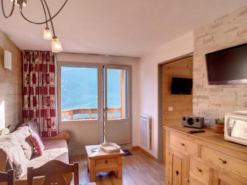 a living room with a couch and a large window at Appartement Confort 1 chambre, ski aux pieds, balcon, Wi-Fi, parking - FR-1-178-171 in Les Bruyères