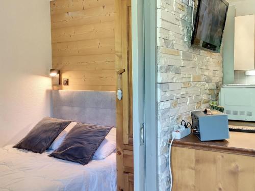 ein Schlafzimmer mit einem Bett neben einer Ziegelwand in der Unterkunft Appartement Les Menuires, 2 pièces, 2 personnes - FR-1-178-171 in Les Bruyères