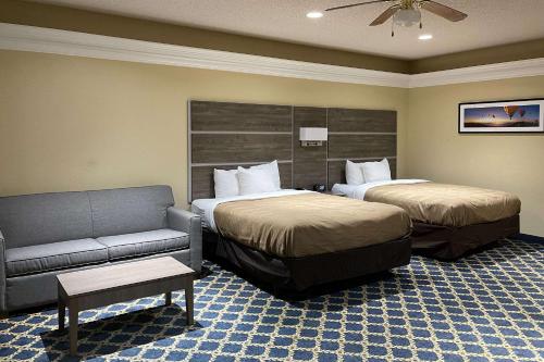 a hotel room with two beds and a couch at Quality Inn Thomasville-Northpark in Thomasville