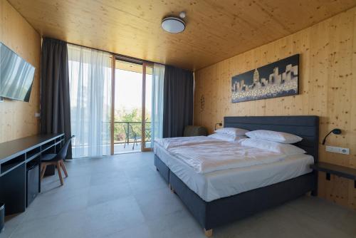 a bedroom with a bed and a desk and a window at Depandance hotelu Vítkova Hora in Karlovy Vary