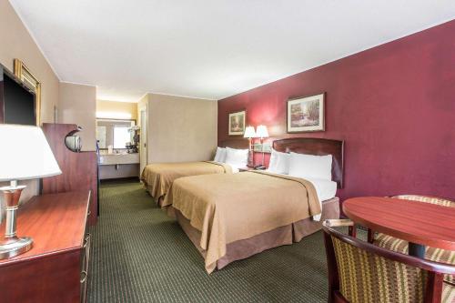 a hotel room with two beds and a table at Quality Inn in Tifton