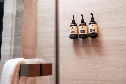 a shower with three blow dryers hanging on a wall at EAST Hong Kong in Hong Kong