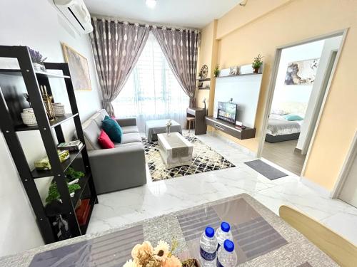 un soggiorno con divano e TV di GOLDEN TROIKA KOTA BHARU - 2 bedrooms a Kota Bharu