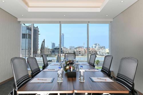 a long table in a room with a large window at Comfort Hotel Jeddah King Road in Jeddah