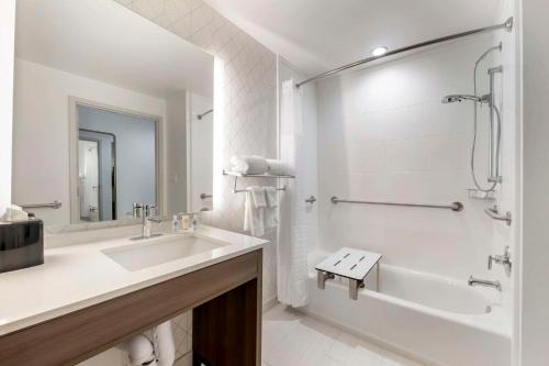 聖奧古斯丁的住宿－Comfort Suites St Augustine Historic District Area，白色的浴室设有浴缸、水槽和淋浴。