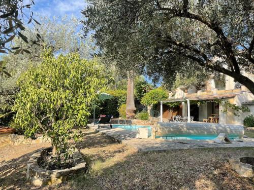 ein Haus mit einem Pool und einem Baum in der Unterkunft Belle villa de charme avec piscine in Tourrettes