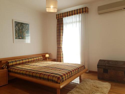 a bedroom with a bed and a large window at Casa da Estrela in Seia