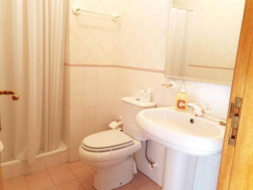 a white bathroom with a toilet and a sink at Casa da Estrela in Seia