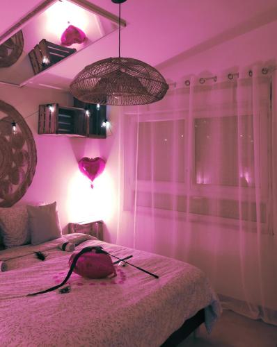- une chambre rose avec un lit au plafond rose dans l'établissement La loveroom de l'Artois, à Souchez