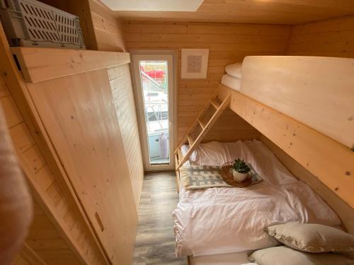 um quarto com um beliche num chalé de madeira em Hausboot Yara am Steg 1D em Heiligenhafen