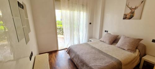a bedroom with a bed and a large window at Bel appartement Savannah Beach in Sidi Rahal