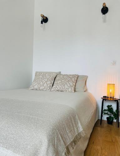 a bedroom with a white bed with a white comforter at Chez Alex in Asnières-sur-Seine
