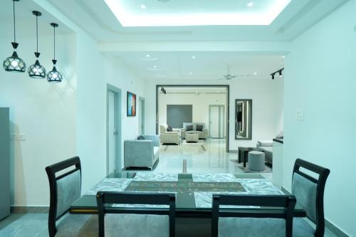 a dining room with a glass table and chairs at BIGSON SERVICE APARTMENTS MADHAPUR in Hyderabad