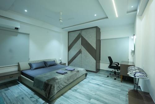 a bedroom with a bed and a desk and a chair at BIGSON SERVICE APARTMENTS MADHAPUR in Hyderabad
