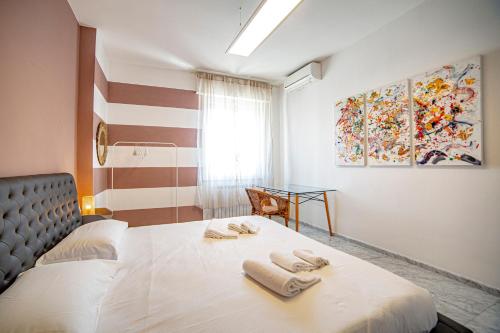 1 dormitorio con 1 cama con 2 toallas en Elegante camera con finiture di lusso appena ristrutturata en Marina di Carrara