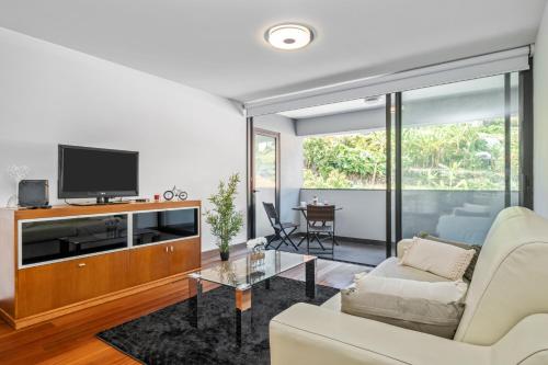 a living room with a couch and a tv at EDU FLAT in Machico