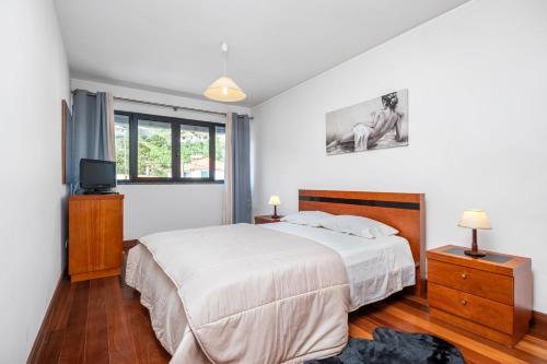 a bedroom with a bed and a television in it at EDU FLAT in Machico