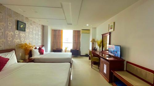 um quarto de hotel com duas camas e uma televisão em Gold hotel, Saigon em Ho Chi Minh