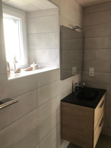 baño con lavabo, espejo y ventana en Penty de Kervillerm, en Douarnenez